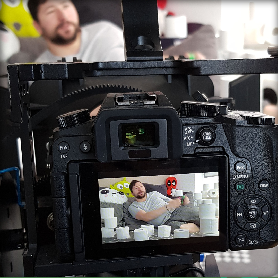 Kamera mit einem Mann der auf einem Sofa mit Klopapier